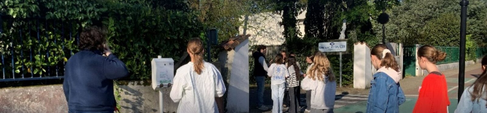 Des élèves du Pôle en repérage devant le portail de l'école, un adulte photographie le lieu